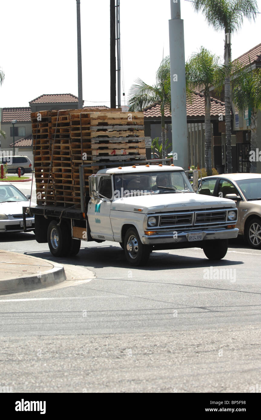 Un uomo di unità e Old Ford Truck impilati alta con pallet. Foto Stock