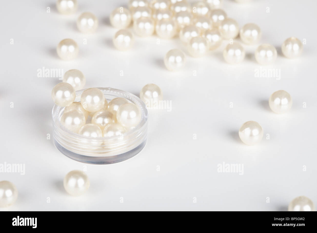 Le perle artificiali sono sparse sfondo luminoso Foto Stock
