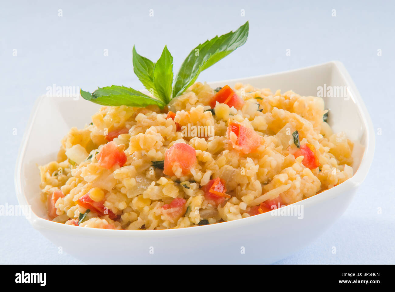 Insalata,semole con lenticchie rosse e le foglie di menta in un bianco bawl Foto Stock