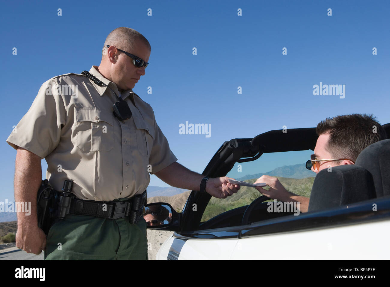 Poliziotto dando conducente velocizzando il biglietto Foto Stock