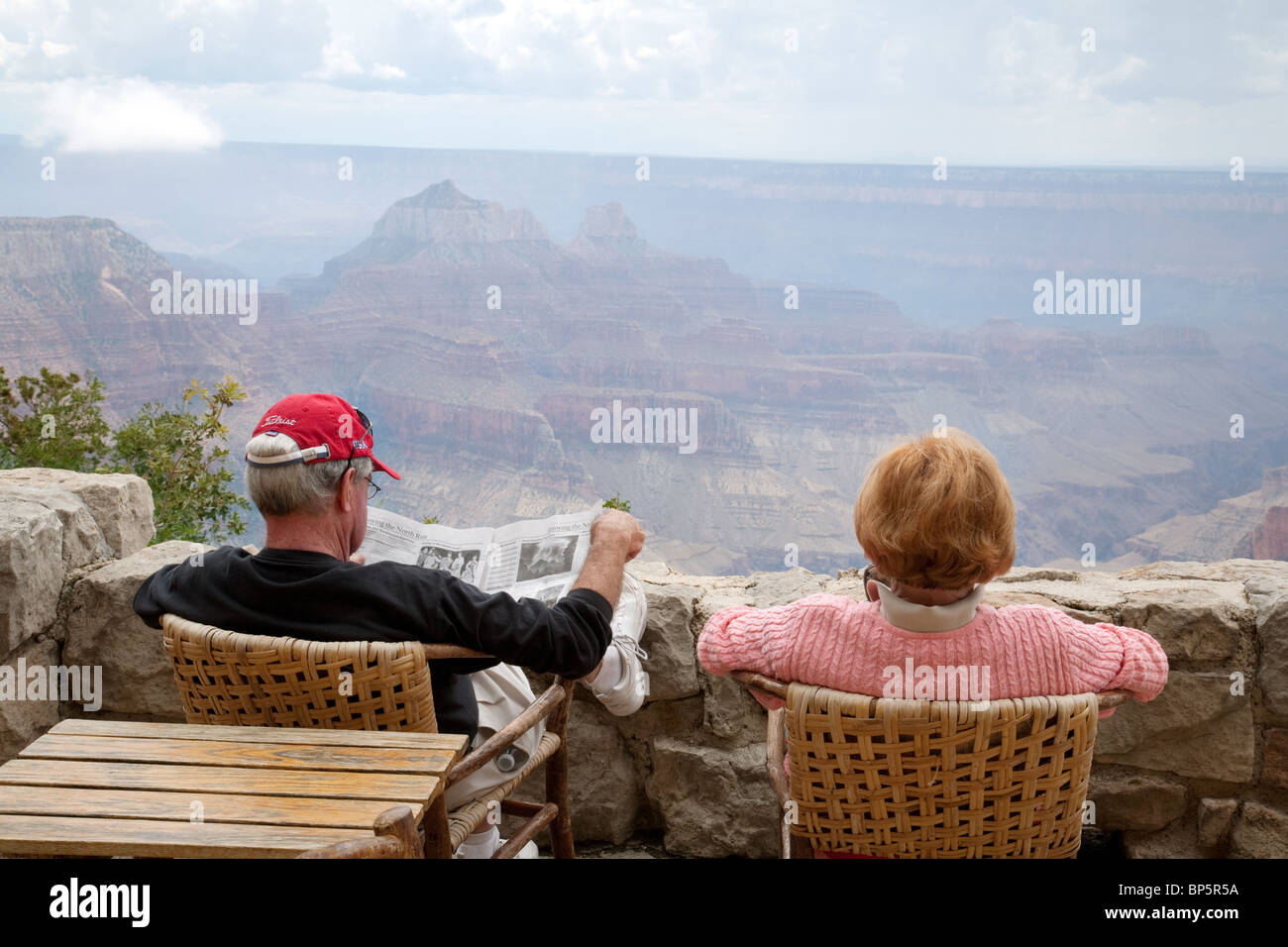 I turisti leggendo un giornale mentre guardando il Grand Canyon dal North Rim Grand Canyon Lodge, Arizona, Stati Uniti d'America Foto Stock