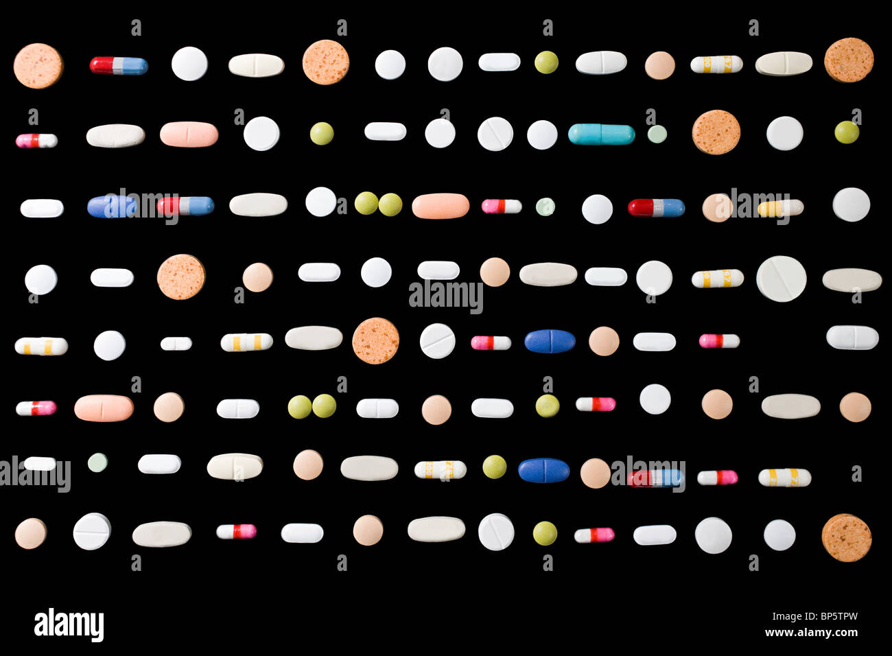 Righe di pillole su sfondo nero Foto Stock