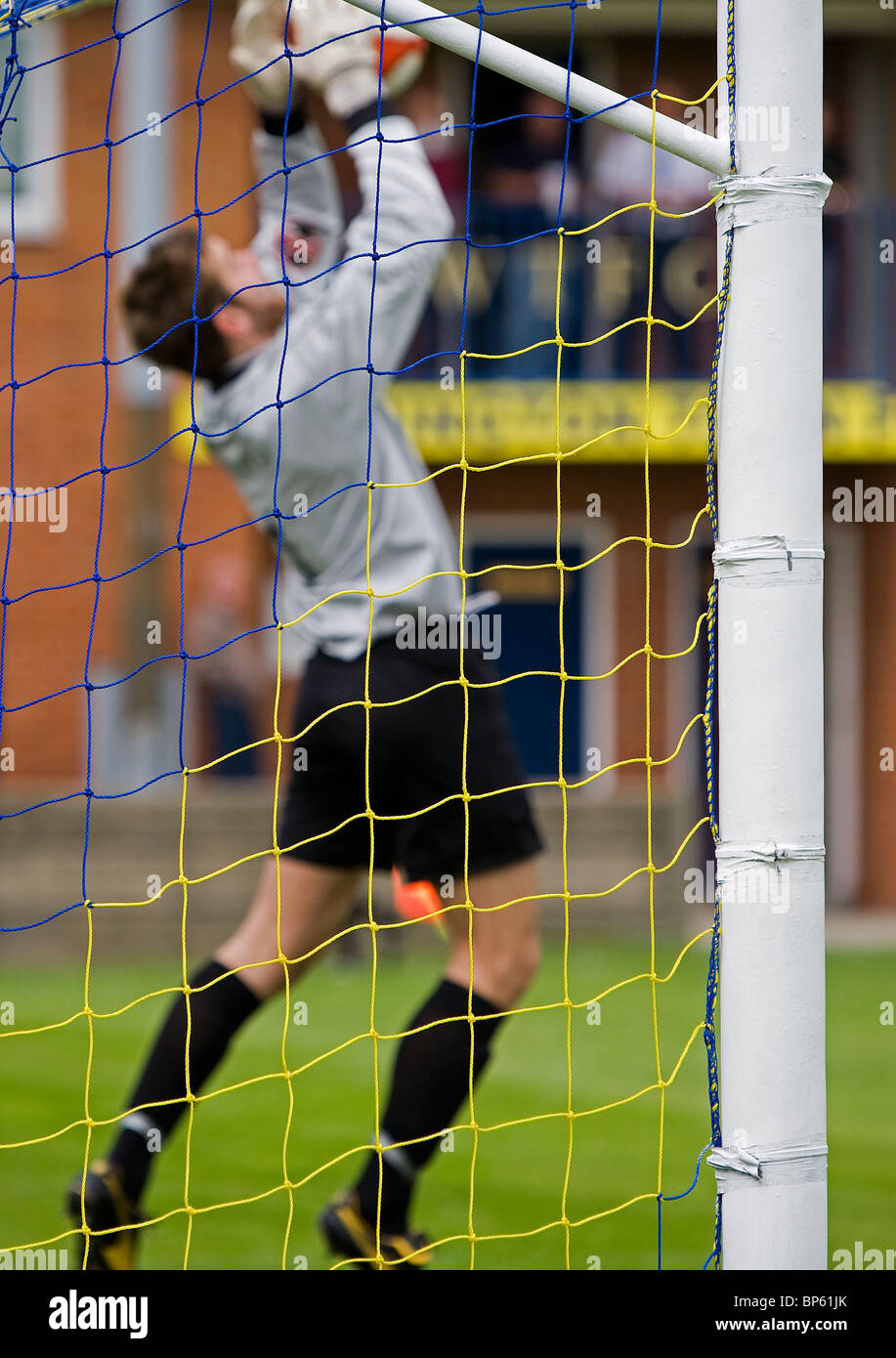 Il portiere fa un salvataggio di fronte gli spogliatoi e gli uffici della città di Warrington A.F.C. Foto Stock