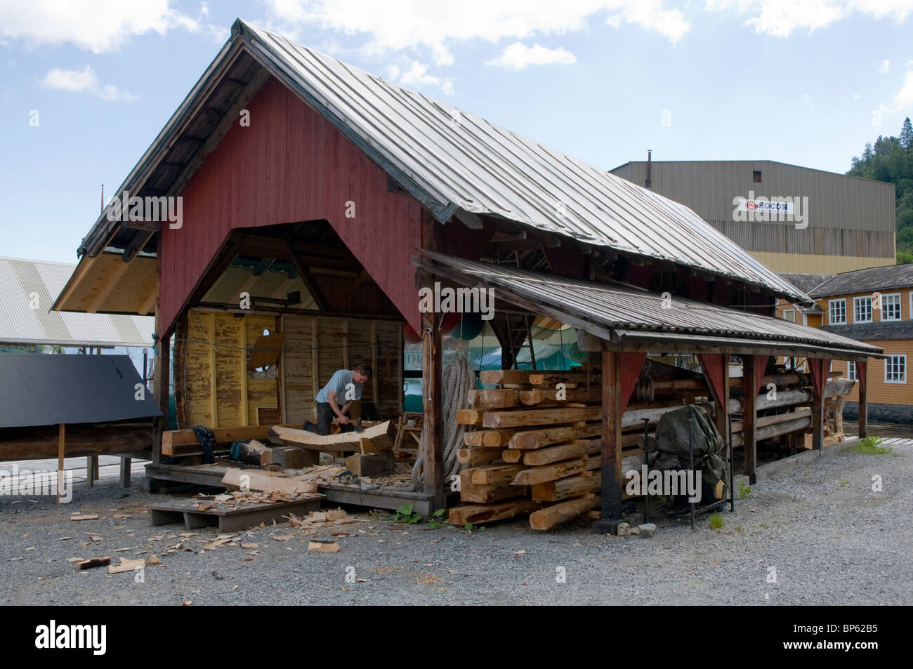 Il taglio di una nervatura in barca a forma con un'ascia utilizzando tecniche tradizionali. Ampio angolo di ferratura la barca-la costruzione di un capannone. La Norvegia. Foto Stock
