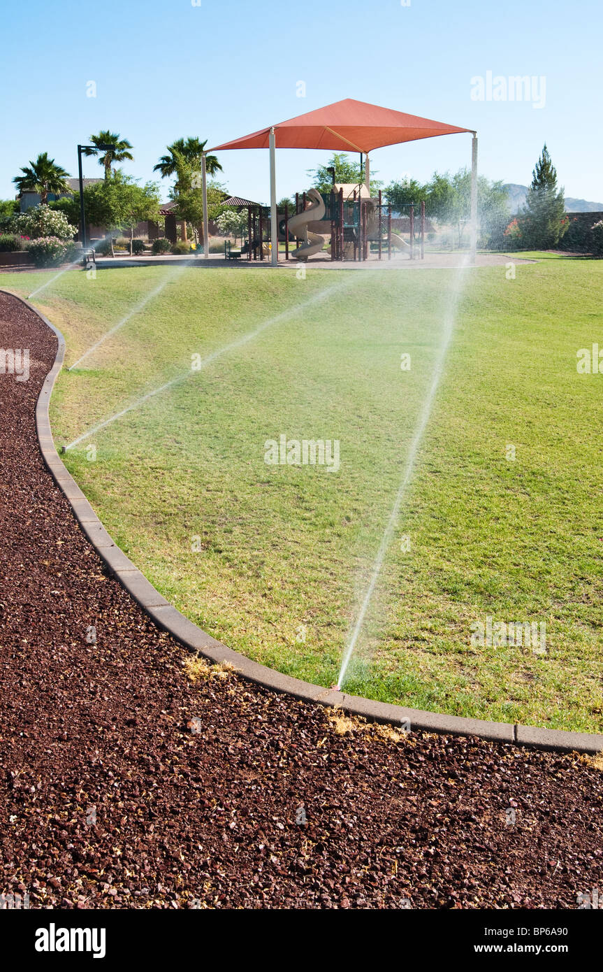 Un sistema di irrigazione automatica viene utilizzata per l'acqua dell'erba in un parco cittadino in Arizona. Foto Stock