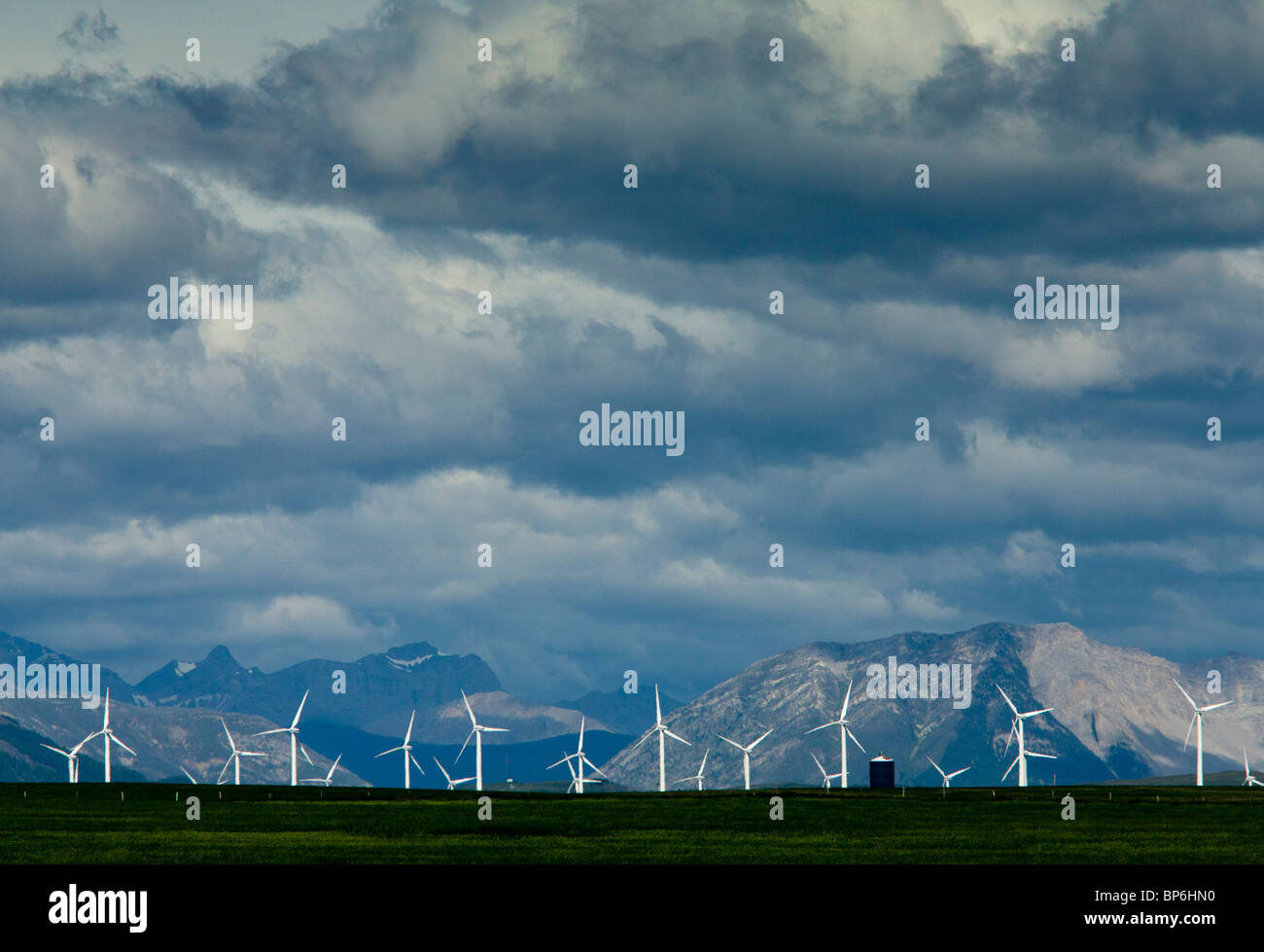 Mulini a vento in corrispondenza dei rulli di estrazione Creek, Alberta, con le Montagne Rocciose oltre, nelle tempeste; Canada Foto Stock