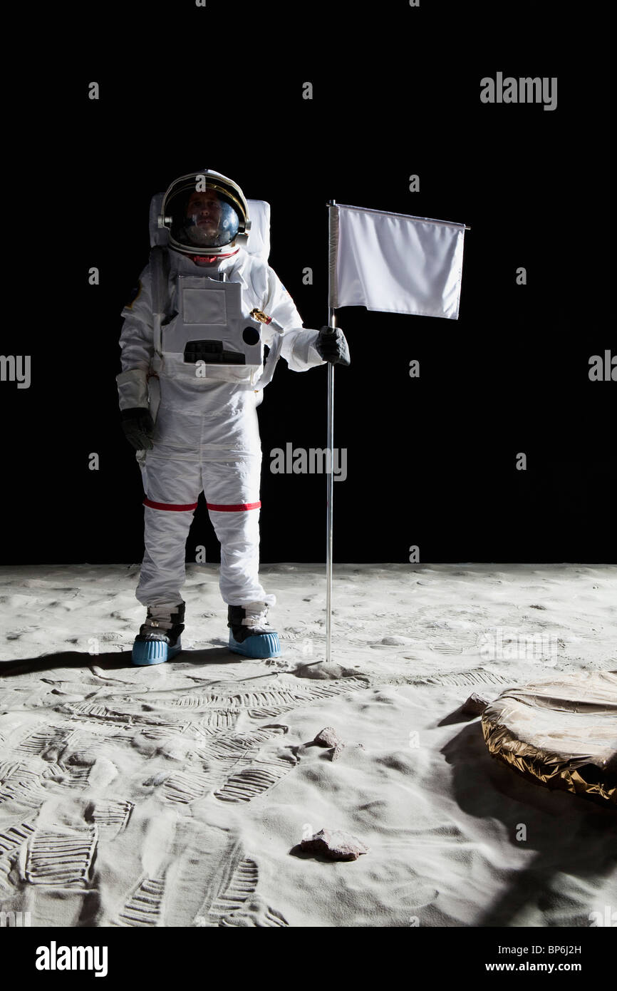 Un astronauta in piedi accanto a una bandiera bianca Foto Stock