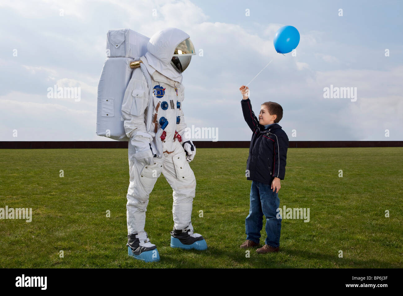 Un ragazzo tenendo fuori un palloncino di un astronauta Foto Stock