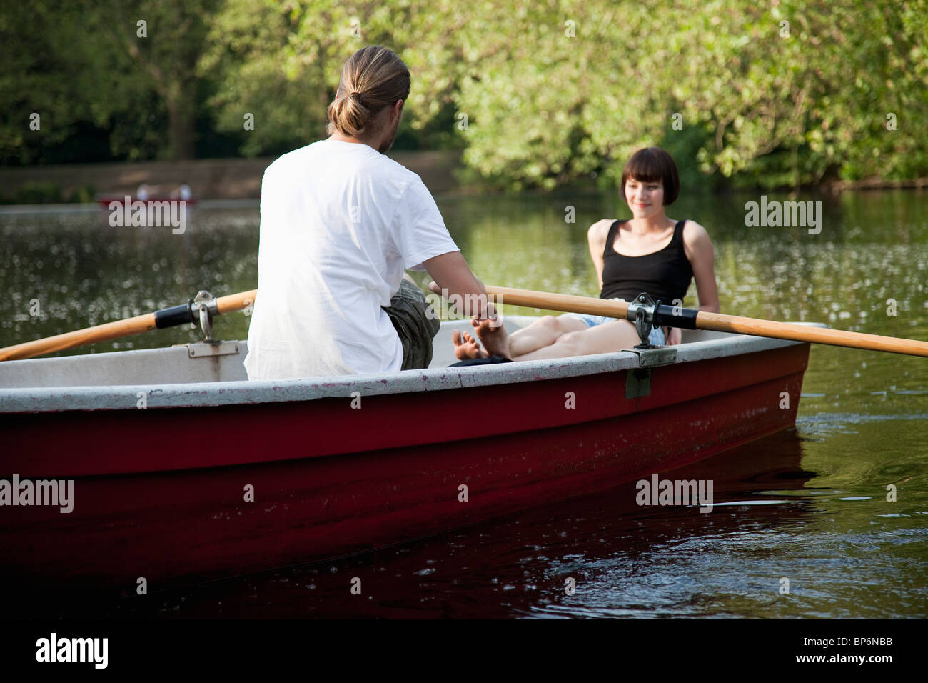 Una giovane coppia in una barca a remi Foto Stock