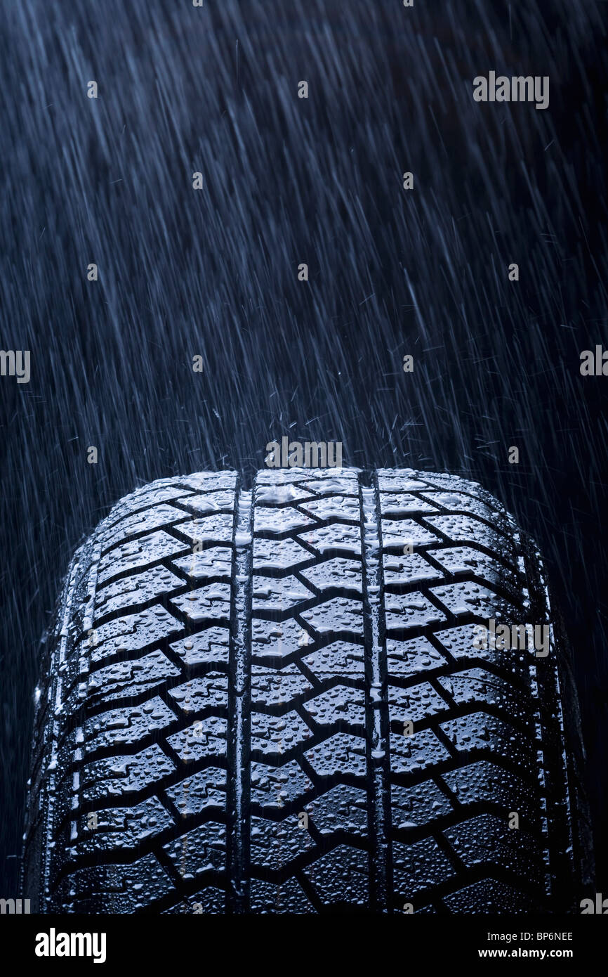 Dettaglio della pioggia che cade su di un pneumatico di una macchina Foto Stock