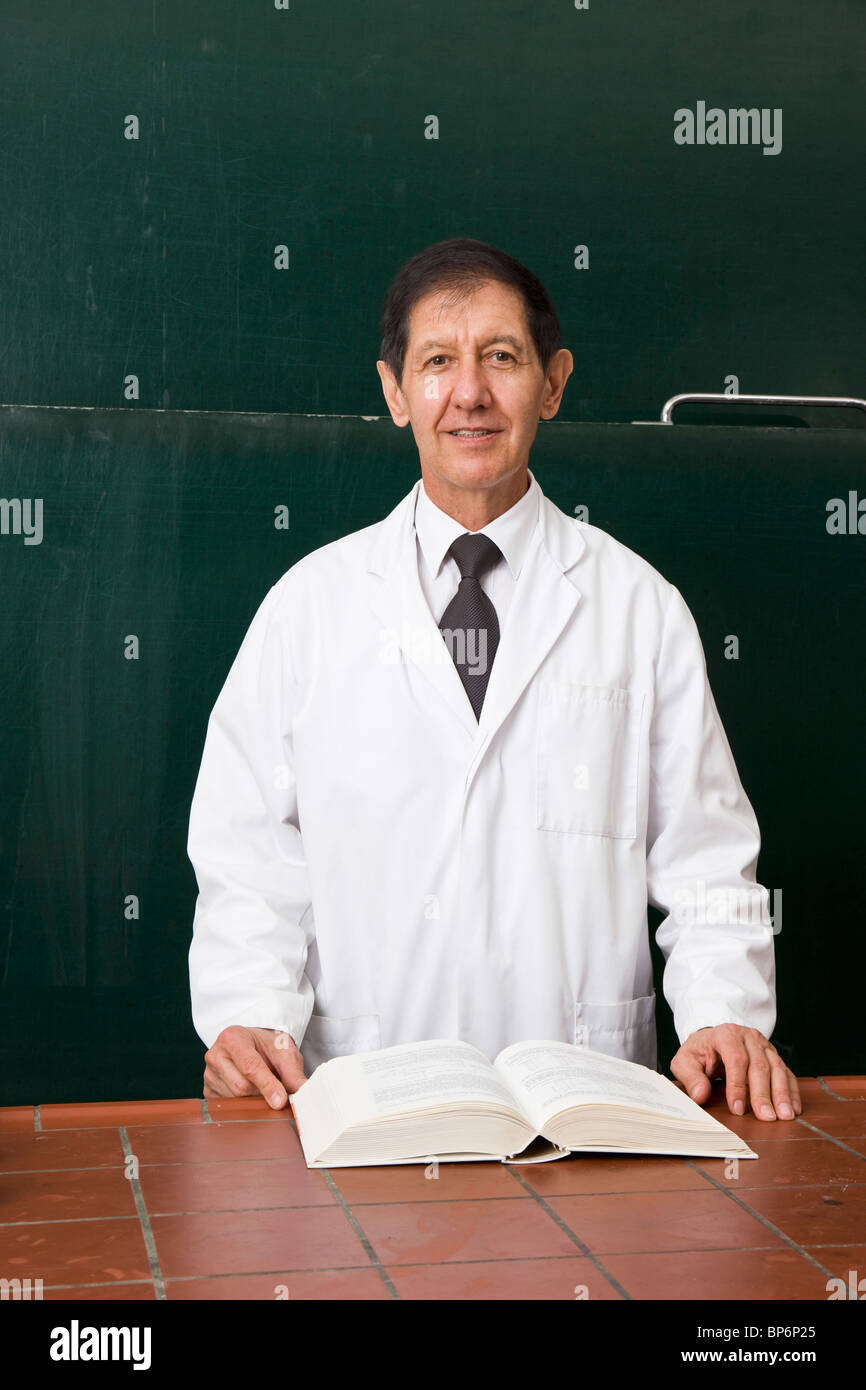 Ritratto di un insegnante di scienze con un libro di testo aperto nella sua classe Foto Stock