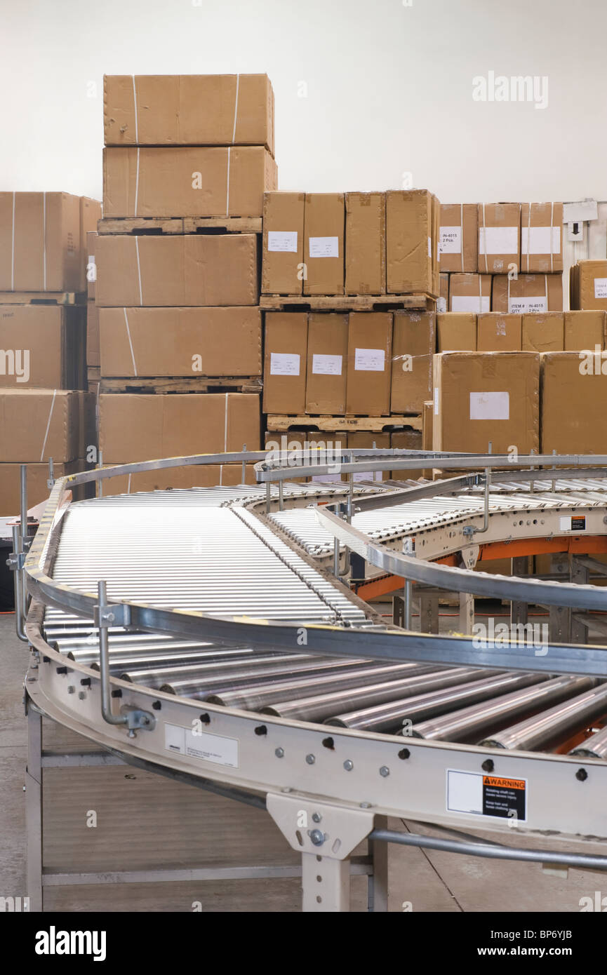 Scatole di cartone e nastro trasportatore nel magazzino di distribuzione Foto Stock