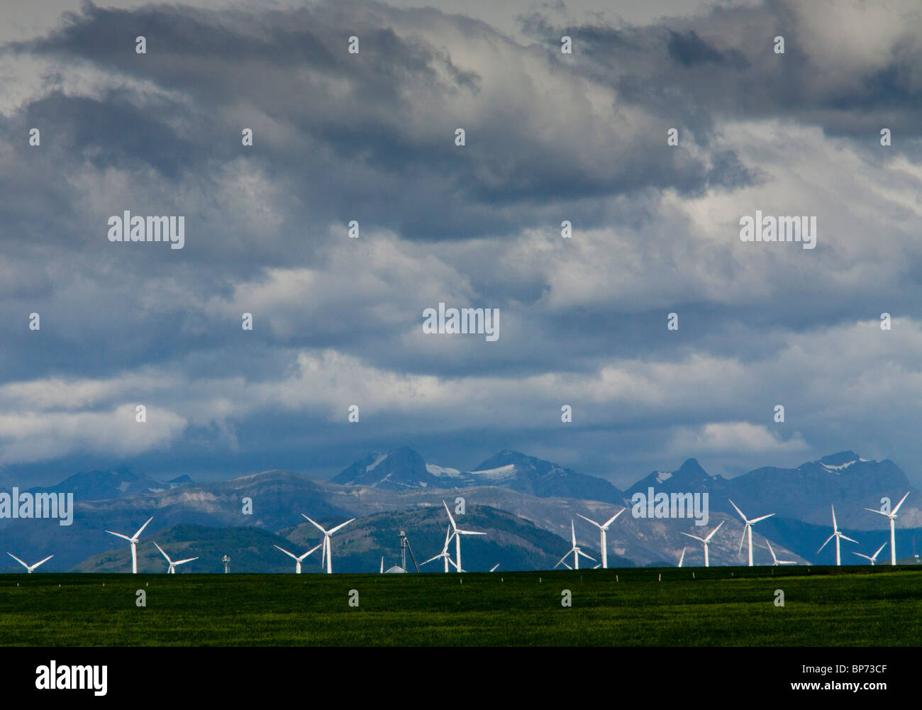 Mulini a vento in corrispondenza dei rulli di estrazione Creek, Alberta, con le Montagne Rocciose oltre, nelle tempeste; Canada Foto Stock