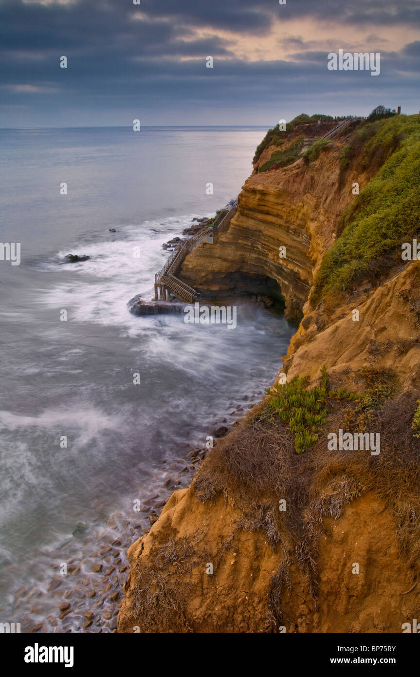 Nebbia costiera nuvole, le onde che si infrangono e giovane che si affacciano sull'Oceano Pacifico a Sunset Cliffs, San Diego, California Foto Stock