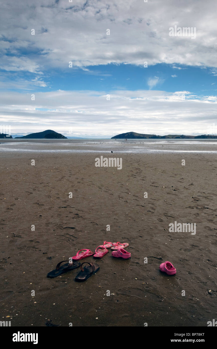 Sandles sulla spiaggia Shelly in Coromandel, Nuova Zelanda. Foto Stock