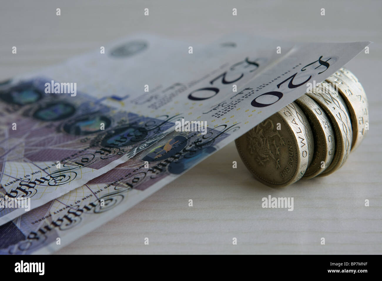 Denominazione diversa sterling note in appoggio su £1 monete Foto Stock