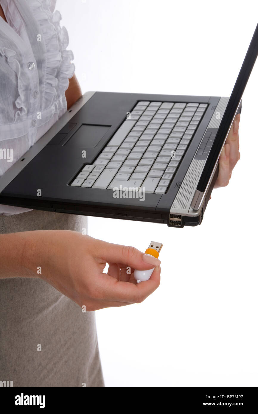 Donna che utilizza memory stick USB su laptop - prodotto Foto Stock