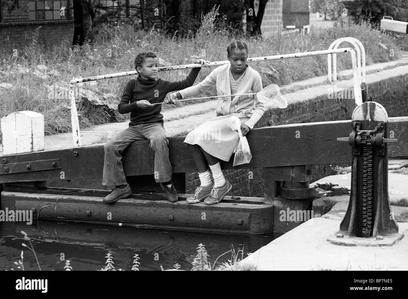 Bambini che pescano con la rete sul canale a Wolverhampton 1980. Foto di DAVID BAGNALL. Regno Unito 1980 nero paese afro Caraibi Foto Stock