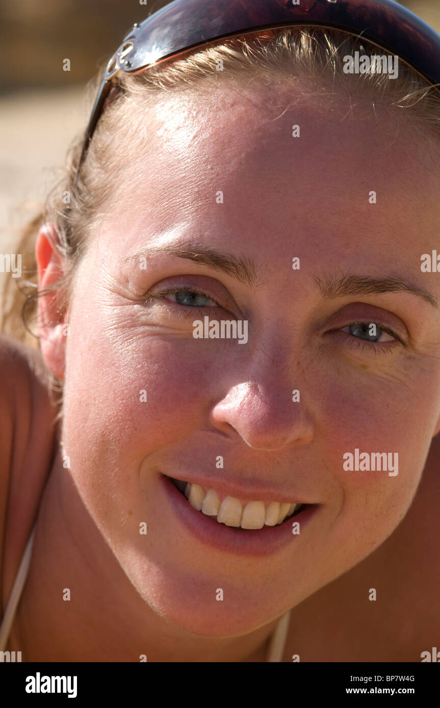 Ritratto di una donna sorridente con gli occhiali da sole sul suo capo Foto Stock