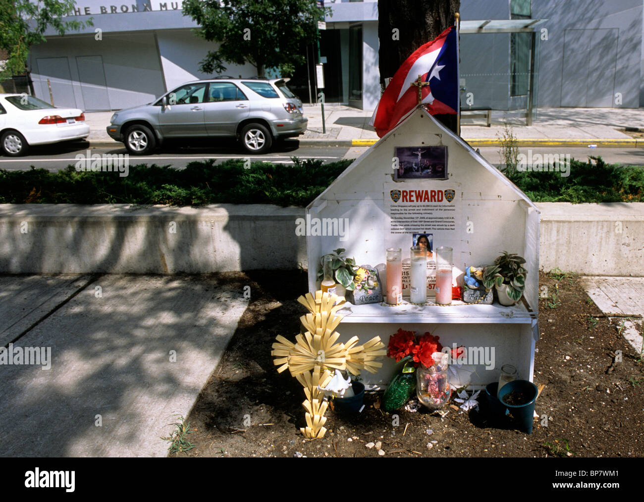 The Bronx, New York City, USA. Memorial per vittima di un incidente colpito e gestito. Fiori candele e una bandiera portoricana in ricordo per persona uccisa. Foto Stock