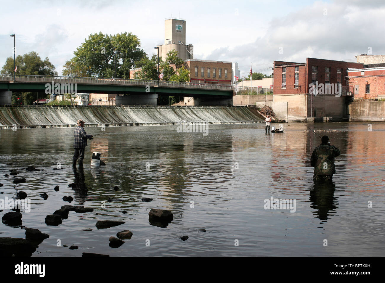 Gli uomini la pesca sotto testa bassa piccola diga idroelettrica Foto Stock