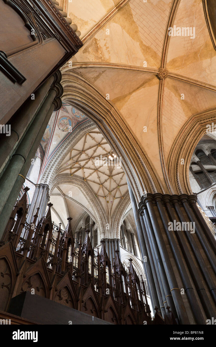 La Cattedrale di Salisbury soffitto e arcate sopra il coro. Le colonne si elevano al soffitto sopra il riccamente intagliato coro Foto Stock