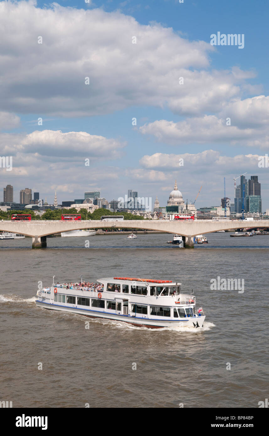 La barca turistica sul fiume Tamigi a Londra, con Waterloo Bridge e St Pauls Cathedral in background. Foto Stock