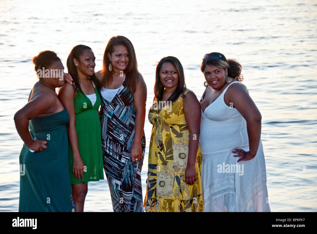 Cinque grandi felice nero americano africano donne amici pongono contro acqua di Puget Sound al tramonto in Edmonds Washington Foto Stock