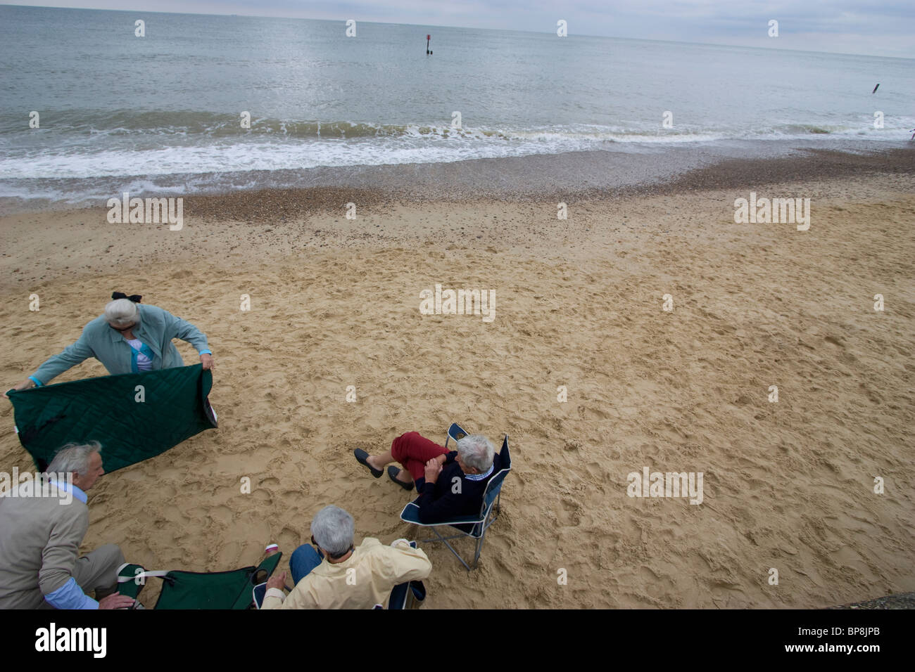 Southwold, suffolk, i pensionati anziani su Southwold Beach mettendo una coperta sulla spiaggia per picnic Foto Stock