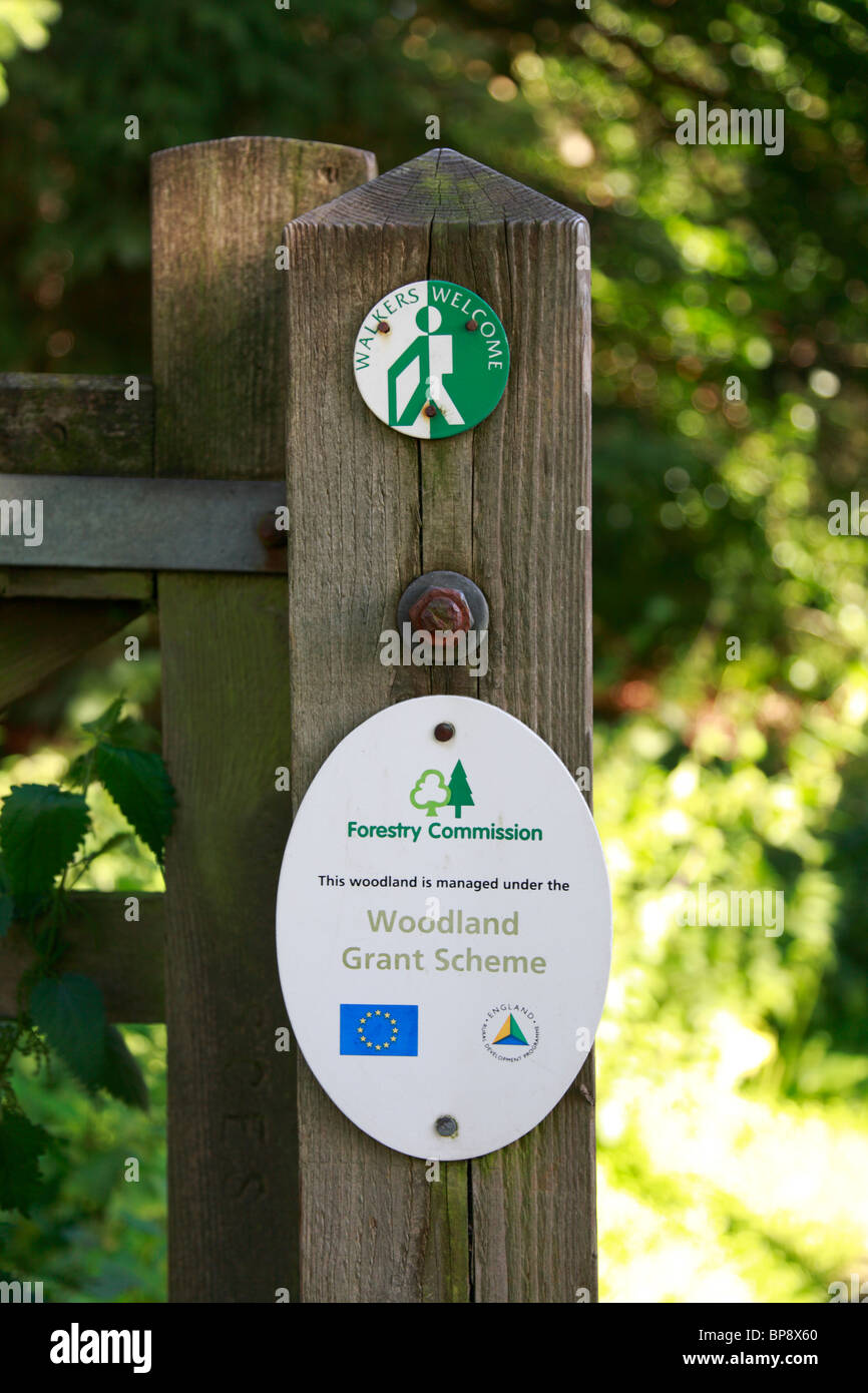 Walkers benvenuti e la Commissione forestale segni su un cancello post vicino Bradfield, Sheffield, Parco Nazionale di Peak District, South Yorkshire, Inghilterra, Regno Unito. Foto Stock