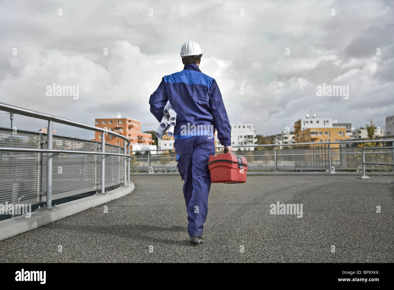 Lavoratore edile che trasportano i piani di costruzione e toolbox, Monaco di Baviera, Germania Foto Stock