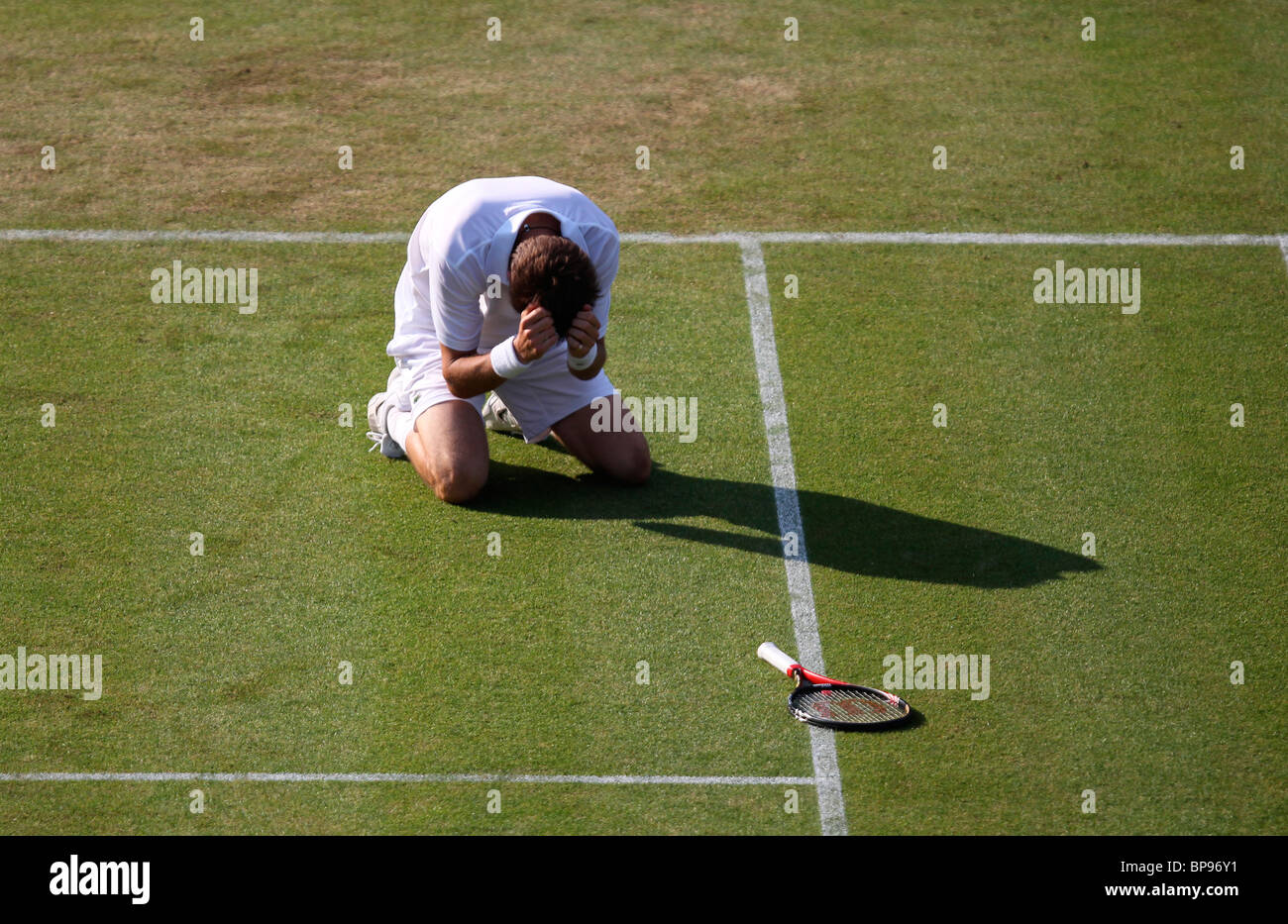 Un devastato Nicolas MAHUT della Francia si inginocchia sulla terra dopo la sua sconfitta a Wimbledon 2010, Foto Stock