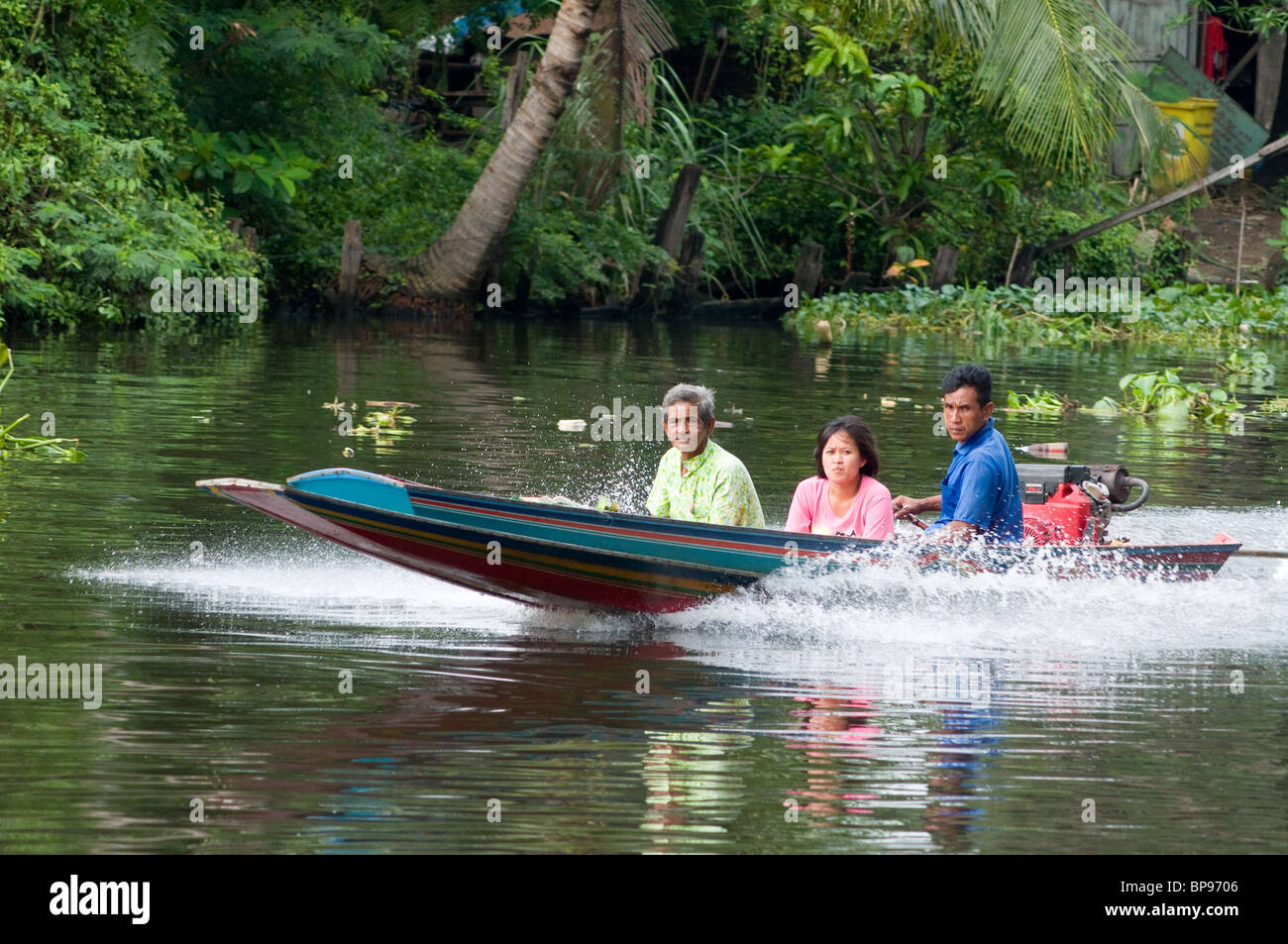 Piccolo longtail boat con tre passeggeri su il Phra Khanong di Klong a Bangkok, in Thailandia. Foto Stock