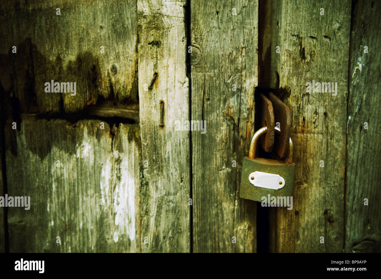 Vecchio lucchetto su un abbandonati porta in legno Foto Stock