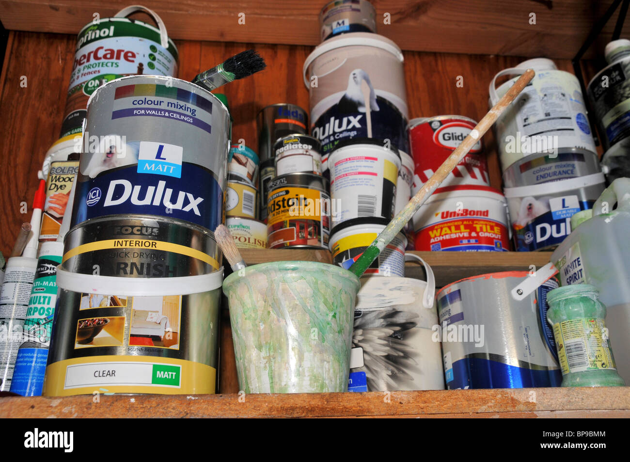 Un ripiano pieno di una varietà di semi utilizzati paint pots e primer.. Foto Stock