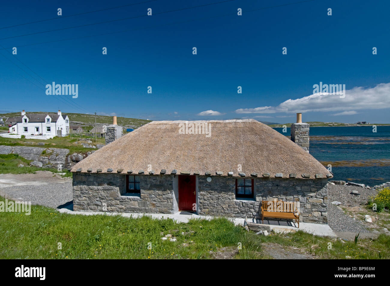 Tradizionale cottage con il tetto di paglia portato fino ai moderni standard si affaccia sulla baia di Loch un Bhaigh, Brough. SCO 6356 Foto Stock