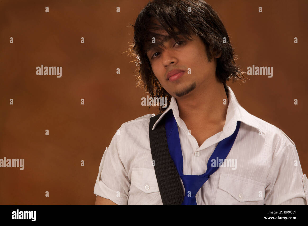 Felice Vestiti Casual giovani asiatici studente di college isolato su sfondo marrone Foto Stock