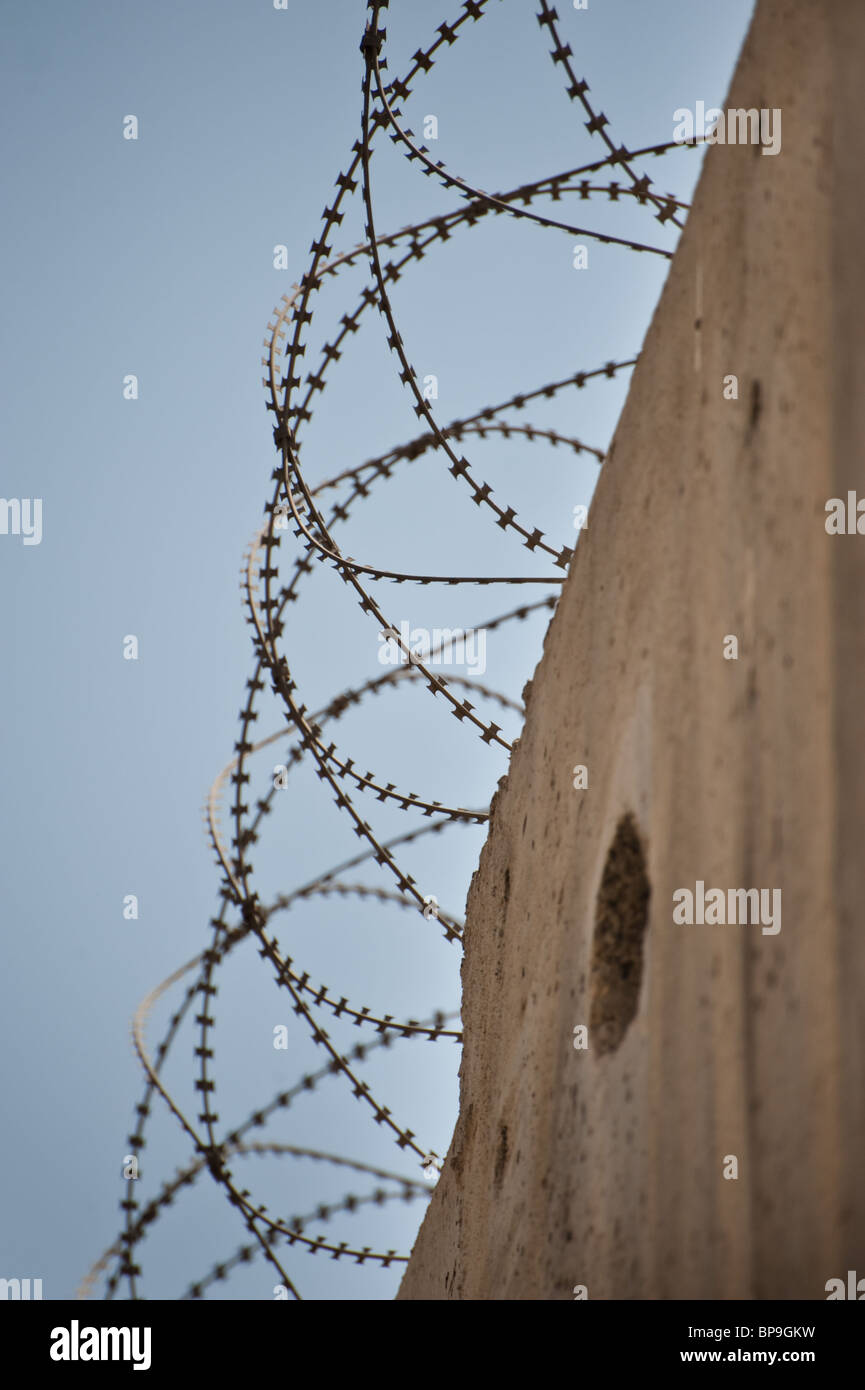 Bobine di filo spinato top israeliano barriera di separazione nel quartiere palestinese di Al-Ram a Gerusalemme Est. Foto Stock