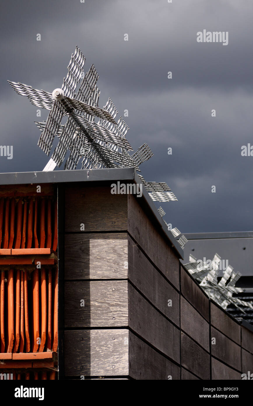 Un cielo grigio minaccioso aggiunge gravità alle misure di sicurezza adottate per proteggere questo edificio dagli intrusi Foto Stock