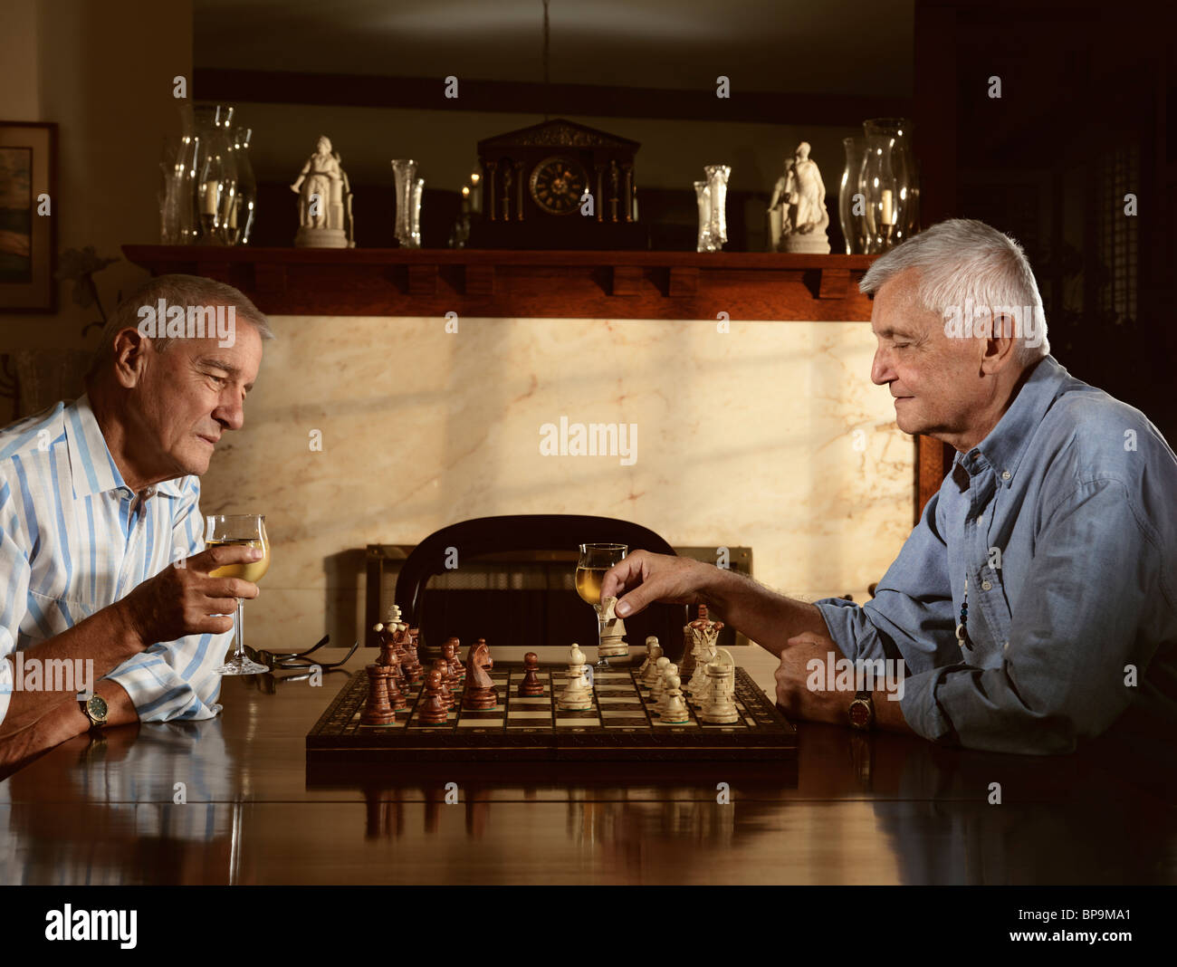 Due anziani godendo di un gioco di scacchi in serata Foto Stock