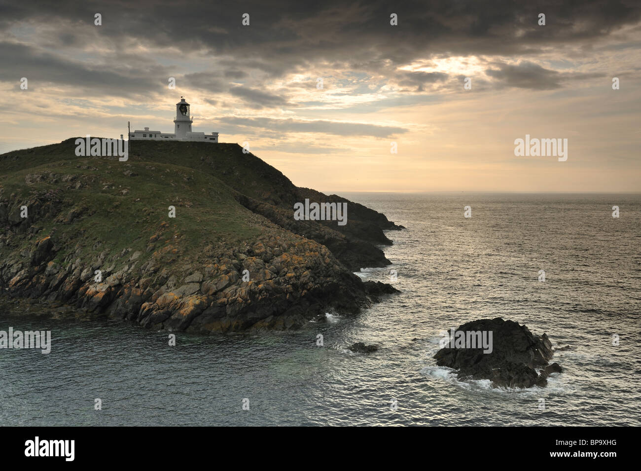 Strumble Head Lighthouse, Pembrokeshire, al tramonto. Foto Stock