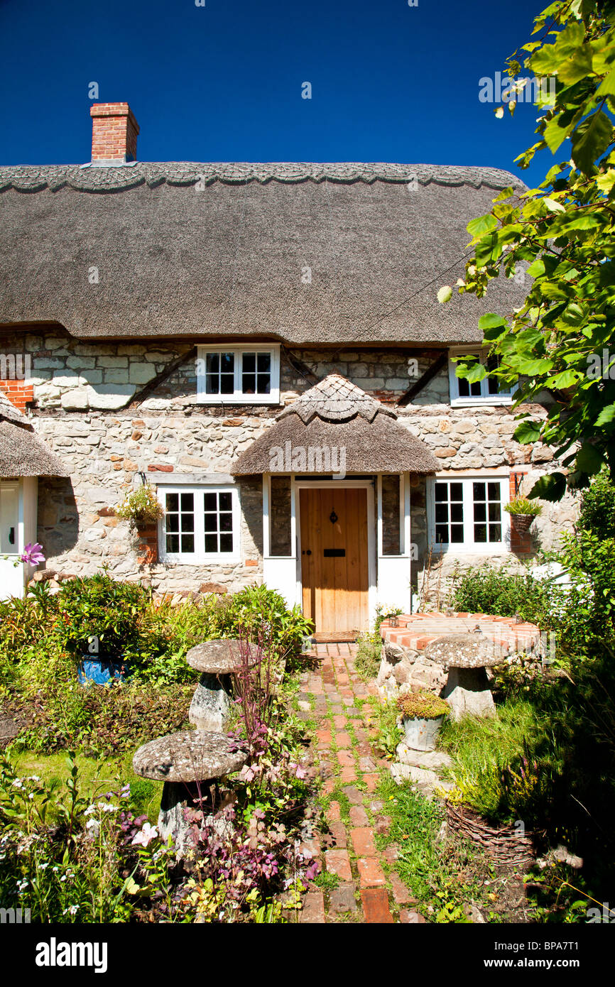 Inglese tipica pietra con il tetto di paglia cottage di campagna in Wanborough, Wiltshire, Inghilterra, Regno Unito Foto Stock
