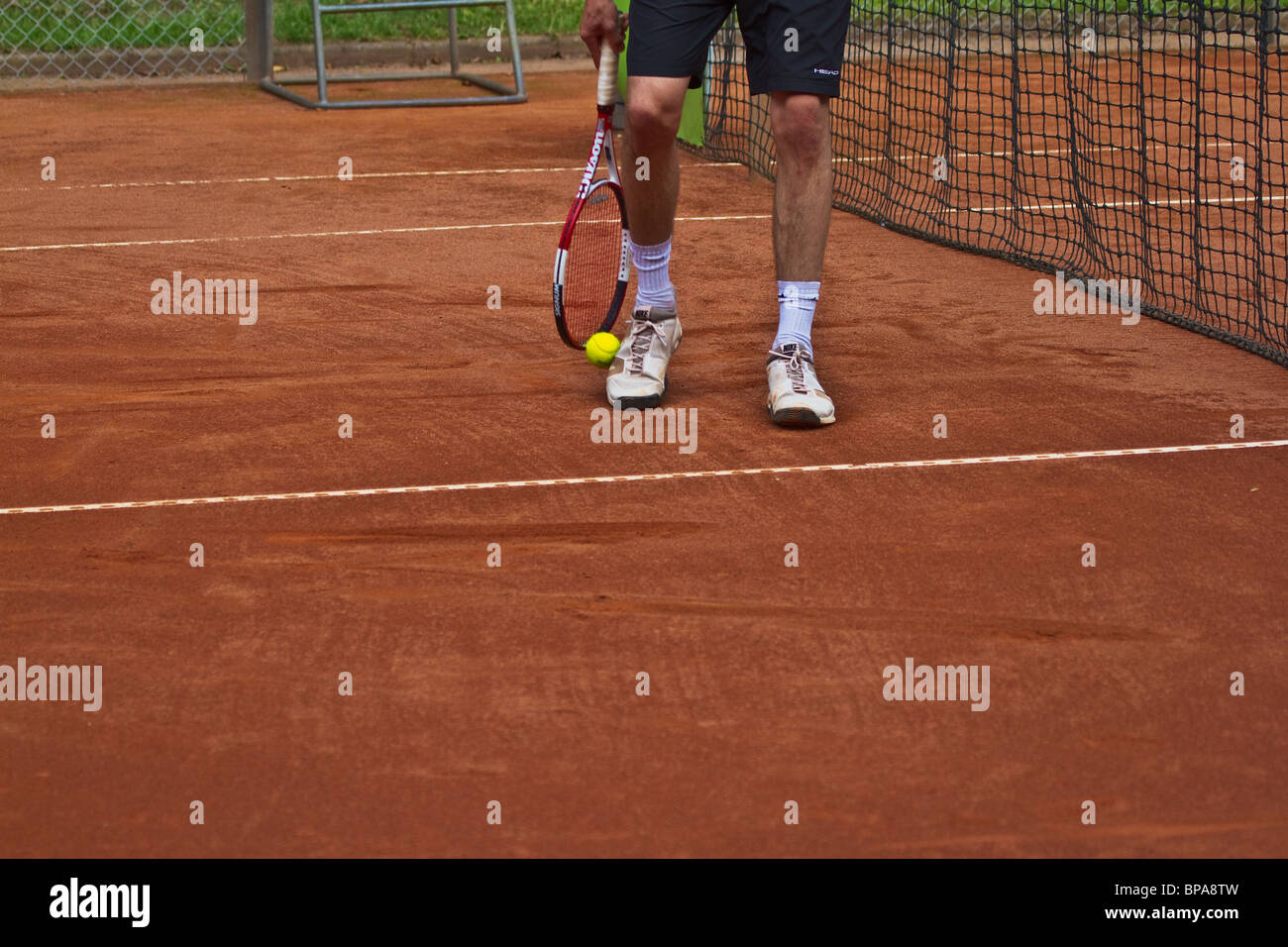 Clay court. Le gambe del giocatore di tennis abile di prelevare la palla con la racchetta. Posizione orizzontale Foto Stock