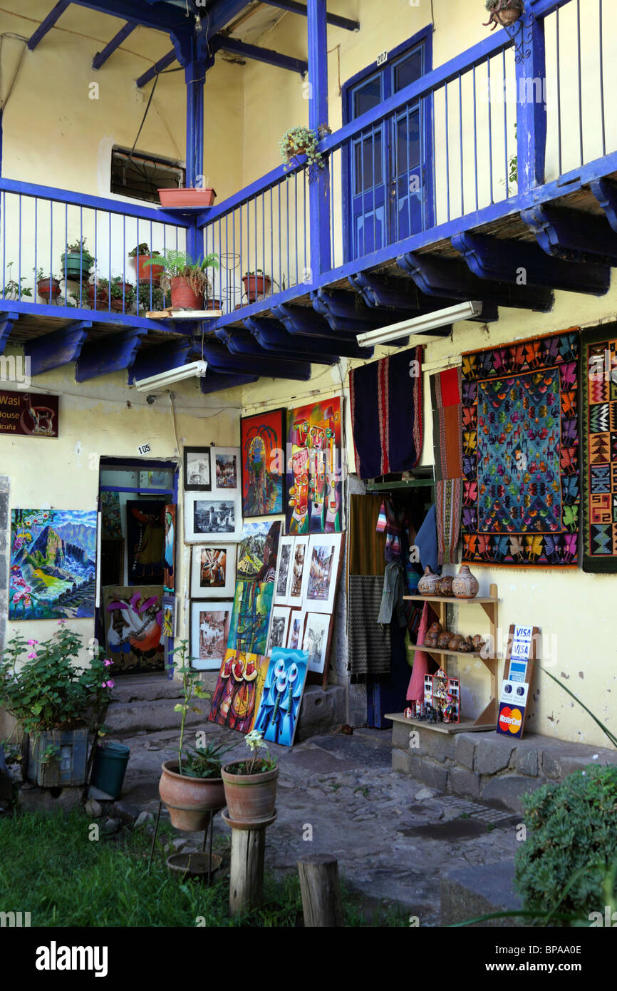 Dipinti e tessiture in vendita in bottega artigianale nel cortile coloniale tradizionale, Cusco, Perù Foto Stock