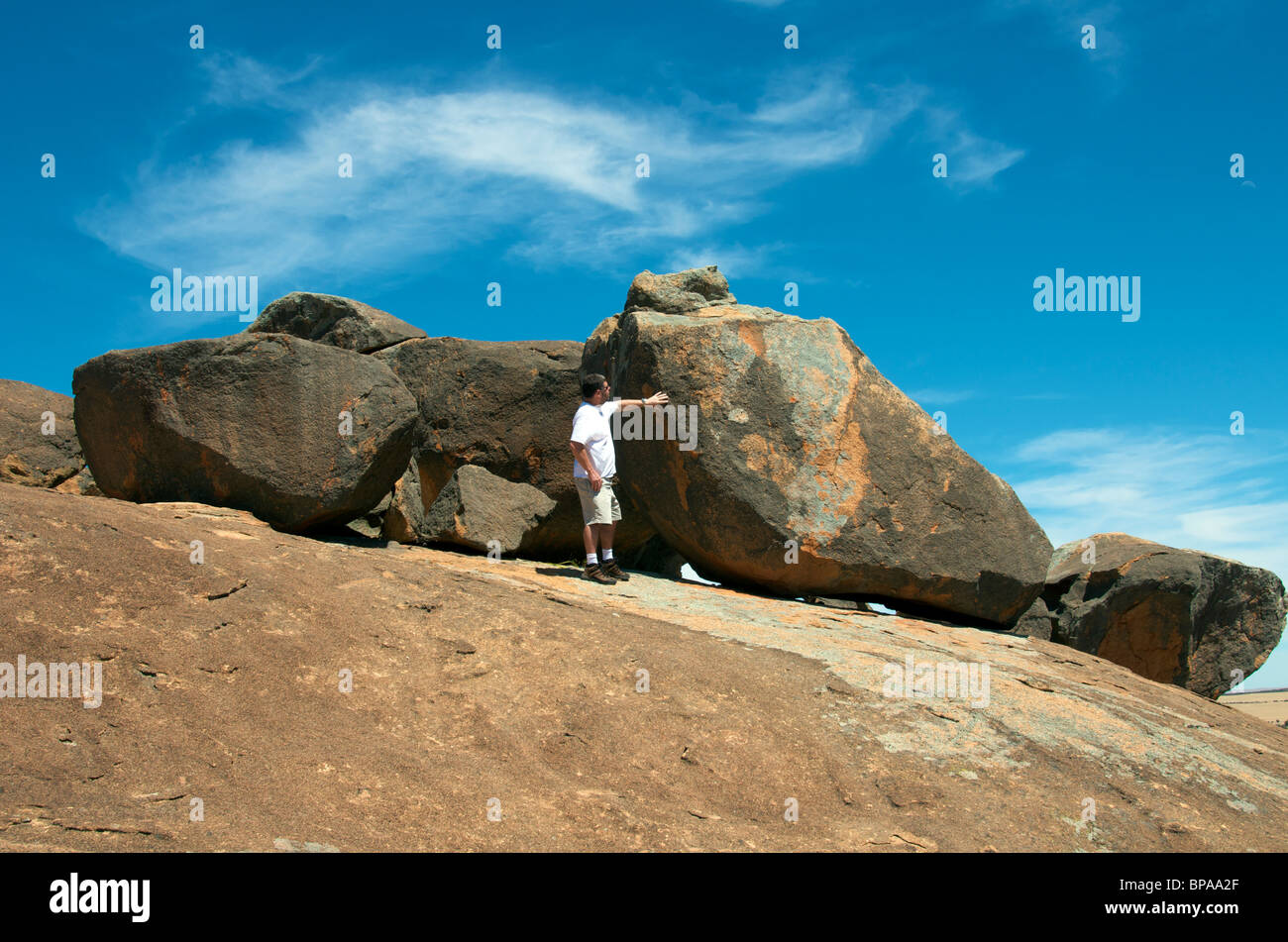 L'uomo esaminando Tafoni su re rocce vicino Hyden Australia Occidentale Foto Stock