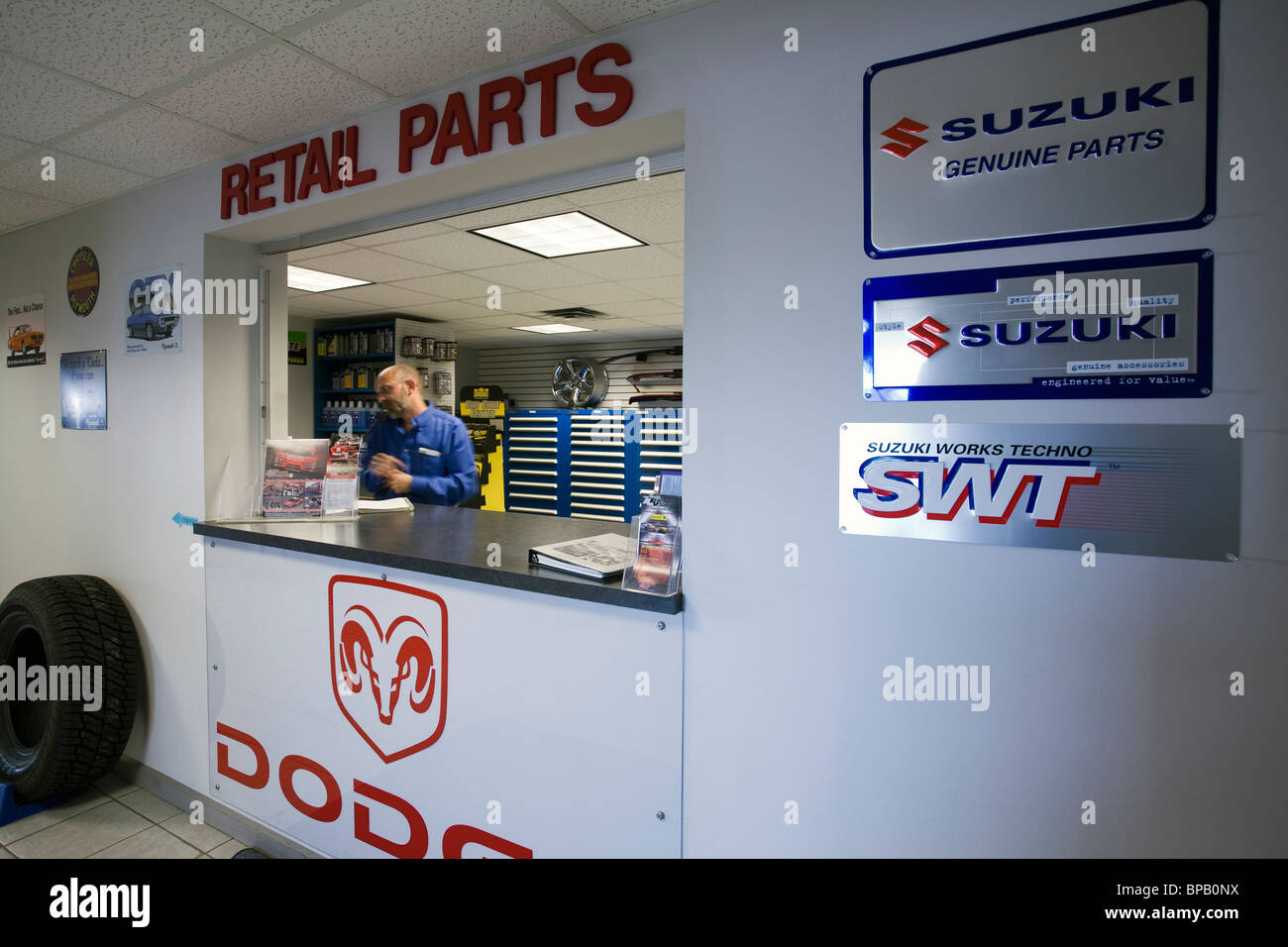 Parti della finestra di reparto in una concessionaria che vende Dodge e Suzuki automobili e camion. Foto Stock