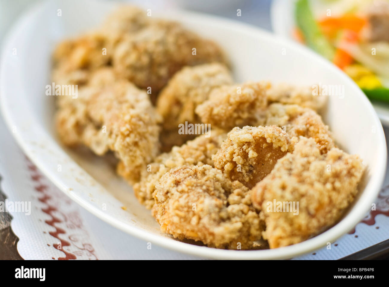 Delizioso fritto di pollo in bianco piatto sul tavolo. Foto Stock