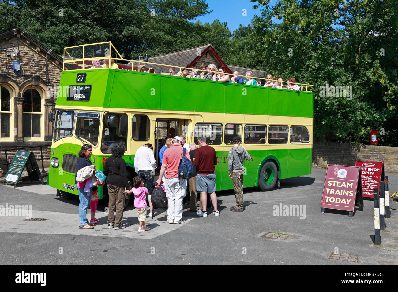 I visitatori di salire a bordo di un open top tour bus fuori Haworth stazione ferroviaria, Haworth, West Yorkshire, Inghilterra, Regno Unito. Foto Stock