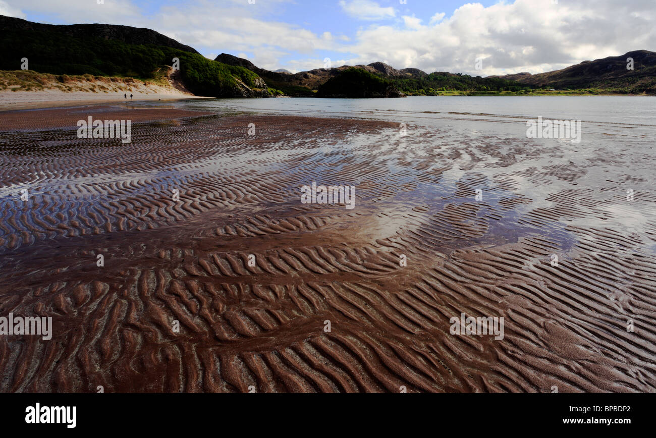 Distante giovane e cane sulla spiaggia di Baia Gruinard Wester Ross Highlands scozzesi Scotland Regno Unito Foto Stock
