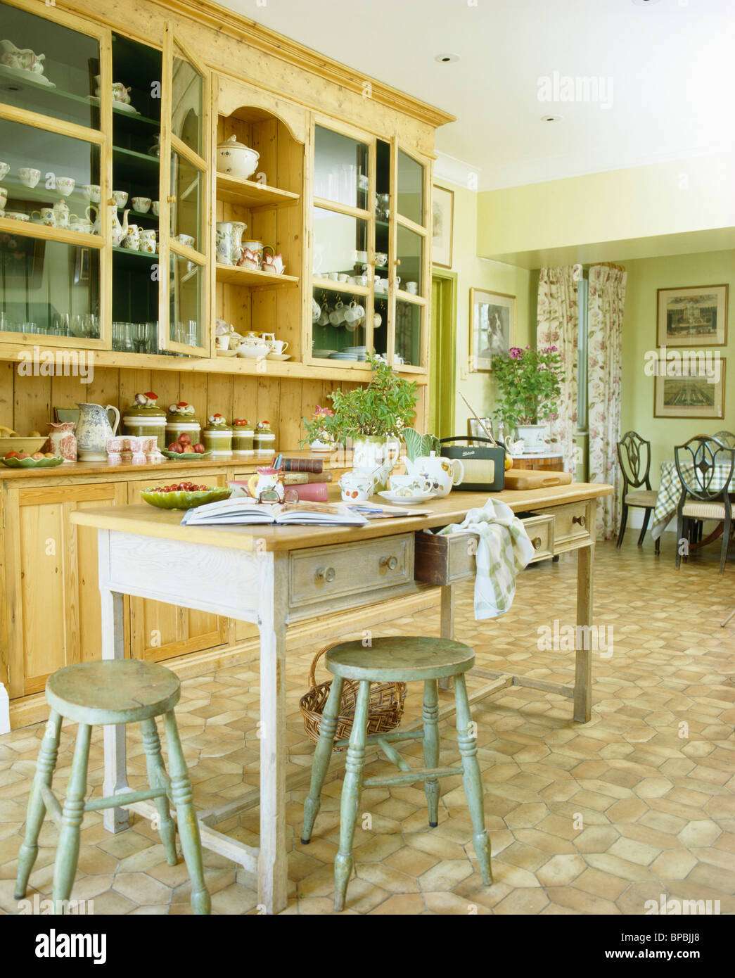 Verde pallido sgabelli e tavolo in legno nella cucina di paese con montato  cassettiera e pavimenti in vinile Foto stock - Alamy